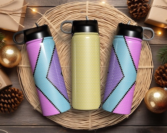 May include: Three stainless steel water bottles with different geometric patterns. The bottles are purple, yellow, and blue with black accents. The bottles are on a woven straw mat.