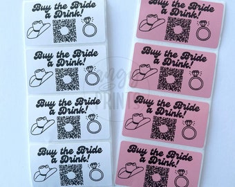 May include: Eight rectangular stickers with the text "Buy the Bride a Drink!" in a cursive font. The stickers have a black and white design with a cowboy hat, a ring, and a QR code. Four of the stickers are white with black text and design, and four of the stickers are pink with black text and design.