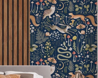 May include: A bedroom with a navy blue wallpaper featuring a whimsical forest design. The wallpaper showcases illustrations of mushrooms, squirrels, owls, snakes, and a rabbit. The room includes a gray bed, a white nightstand, and a white side table.
