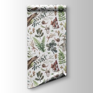 May include: A roll of wallpaper with a forest-themed design. The pattern showcases illustrations of mushrooms, ferns, snails, and other woodland elements in brown, green, and beige against a white backdrop. The paper is rolled, revealing the pattern.
