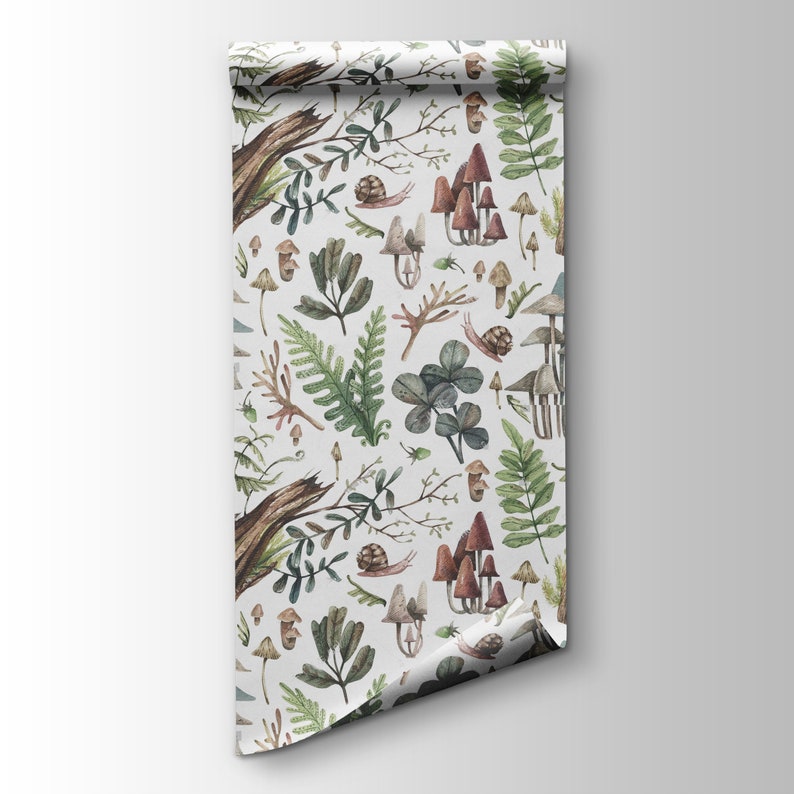 May include: A roll of wallpaper with a forest-themed design. The pattern showcases illustrations of mushrooms, ferns, snails, and other woodland elements in brown, green, and beige against a white backdrop. The paper is rolled, revealing the pattern.