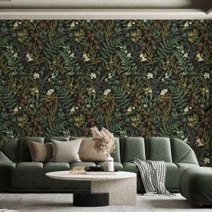 May include: A dark wallpaper featuring a botanical pattern of green, white, and brown foliage against a black background. The image shows a green sofa, a round coffee table, and decorative pillows, creating a cozy living room setting.