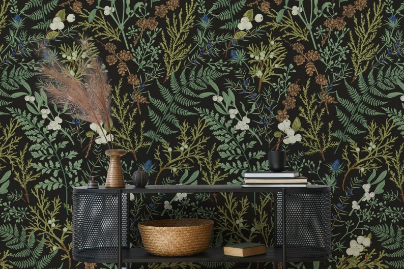May include: Dark wallpaper featuring a botanical pattern with green, brown, and white plant illustrations on a black background. A black metal console table holds a woven basket, books, and decorative vases. The overall theme is nature and home decor.