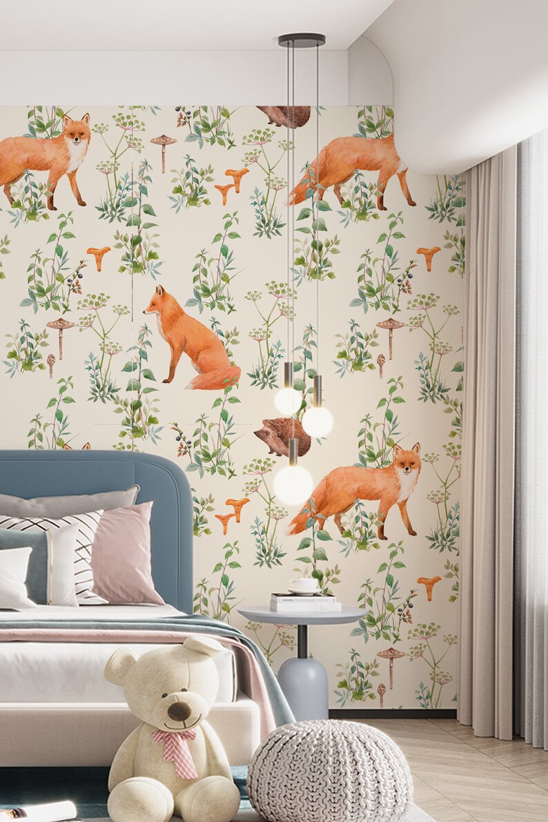 May include: A bedroom with a whimsical forest-themed wallpaper featuring foxes, mushrooms, and greenery. The room includes a blue bed, decorative pillows, a teddy bear, and a small side table. A modern light fixture hangs from the ceiling.
