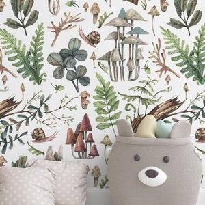 May include: A nursery scene with woodland-themed wallpaper featuring mushrooms, ferns, and snails. A grey bear-shaped storage basket holds toys. Two beige polka-dot pillows are on the floor. The scene is light and airy.