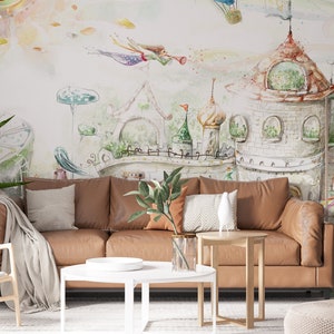May include: A living room with a brown leather sofa, a white coffee table, a green bookshelf, and a whimsical watercolor mural depicting a fairytale castle with flying fairies.