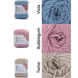 Op de afbeelding: Drie bollen Loops & Threads Classic Cotton garen in Vista blauw, Bubblegum roze en Twine beige. Elke bol is gelabeld met de merknaam, garensoort en afmetingen: 109 m / 71 g.