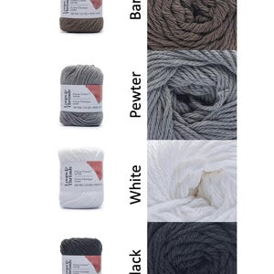 Op de afbeelding: Vier strengen Loops & Threads Classic Cotton garen in verschillende kleuren: Bark, Pewter, White en Black. Elke streng is voorzien van het merk en productdetails. Het garen wordt getoond als streng en als close-up van het gewikkelde garen.