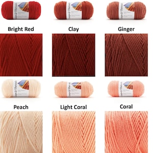 Puede incluir: Una colecci&oacute;n de ovillos de lana en varios colores, incluyendo rojo brillante, arcilla, jengibre, melocot&oacute;n, coral claro y coral. Cada ovillo tiene una etiqueta con la marca "Loops & Threads". La lana se muestra en formato de cuadr&iacute;cula.