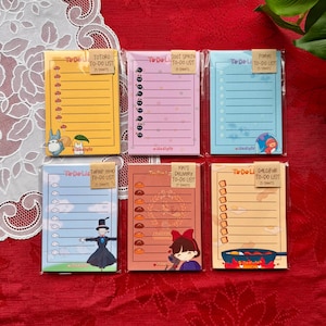 May include: Six colorful To-Do List notepads featuring characters from animated films. Each notepad has a different background color and a unique character illustration. The notepads are labeled with the text "To Do List" and the name of the character.