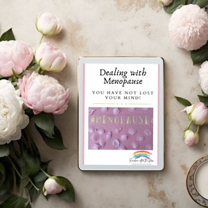 Puede incluir: Una tableta digital que muestra un gráfico rosa y blanco con el texto "Dealing with Menopause You have not lost your mind! #Menopause". La tableta está rodeada de peonías rosas y una taza y un platillo blancos.