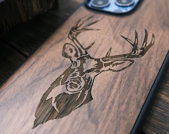 May include: A wooden phone case with a laser-engraved deer head design. The case is brown with a black border.