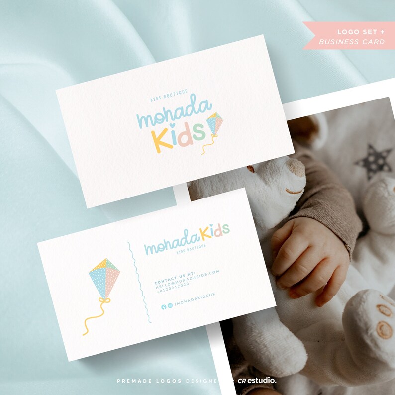 May include: A business card with a logo for a children's boutique called "mohada Kids". The logo features a colorful kite with a heart in the center. The business card includes contact information and the text "Kids Boutique".