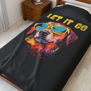 Puede incluir: Funda de cama negra con una colorida ilustración de un perro con gafas de sol. El perro está representado con vibrantes tonos de naranja, amarillo, rosa y azul. Las palabras "LET IT GO" están impresas en dorado.