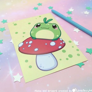 Könnte beinhalten: Ein grüner Comic-Frosch sitzt auf einem roten und weißen Pilz mit weißen Punkten. Der Pilz hat einen weißen Stiel. Der Hintergrund ist gelb mit grünen und weißen Punkten.