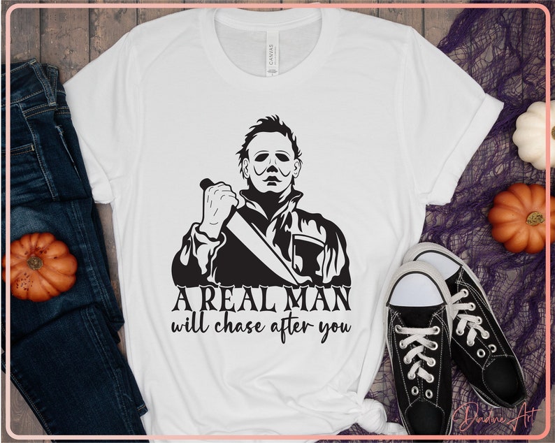 May include: White t-shirt with a black and white graphic of a man holding a knife. The text "A real man will chase after you" is printed below the graphic.