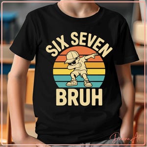 Op de afbeelding: Zwart t-shirt met een afbeelding van een cartoonjongen die dabt voor een zonsondergang. De tekst luidt "SIX SEVEN BRUH" in een speels lettertype, geschikt voor een kinderverjaardag.