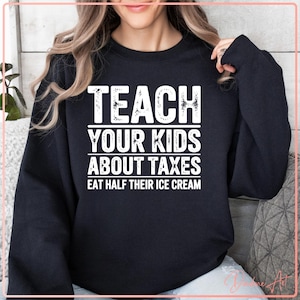 May include: Black sweatshirt with white text that reads "Teach your kids about taxes eat half their ice cream".
