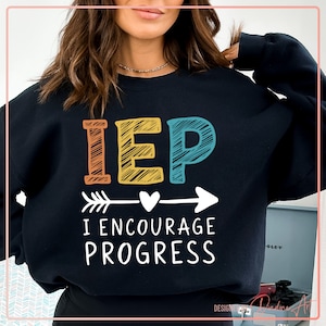 May include: Black sweatshirt with the text "IEP I ENCOURAGE PROGRESS" in colorful letters with an arrow and heart design.