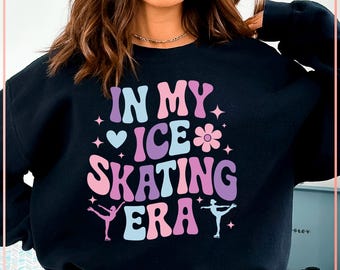 May include: Black sweatshirt with the text "IN MY ICE SKATING ERA" in a retro font. The design includes a heart, flower, and skater illustrations in pink, purple, and blue. A fun, sporty apparel item.