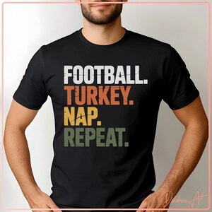 May include: Black crew neck t-shirt featuring the text "FOOTBALL. TURKEY. NAP. REPEAT." in white, orange, yellow, and green block letters. The shirt is being worn by a person.