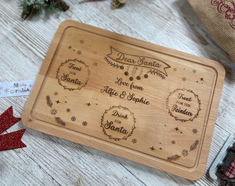 May include: A wooden cutting board with a Christmas theme. It has a message that says "Dear Santa, Love from Alfie & Sophie" and three sections labeled "Treat for Santa", "Drink for Santa", and "Treat for the Reindeer".