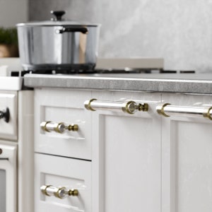 Könnte beinhalten: Weiße Küchenschränke mit gebürstetem Nickel-Beschlag. Die Schränke haben ein elegantes, modernes Design und sind perfekt für jede Küche.