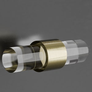 Op de afbeelding: Een transparante acryl kastknop met een geborstelde gouden metalen ring rond het midden. De knop is ontworpen voor gebruik op kasten, lades en deuren.