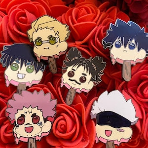 May include: A collection of colorful enamel pins shaped like melting popsicles, each featuring a different anime character with unique facial expressions. The pins are set against a backdrop of vibrant red roses.
