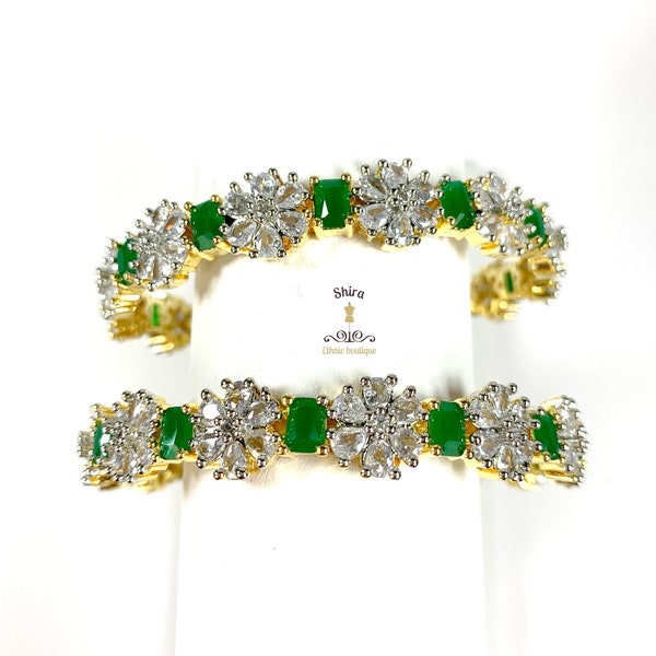 Size: 2.8 American Diamond bangles with big emerald stones and flowers motifs. Set of 2 very pretty diamond look bangles with emeralds.