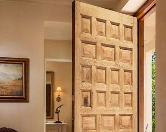 May include: A wooden door with a decorative panel design. The door is open and the interior of a home is visible.