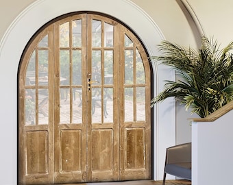 Può includere: Una porta ad arco in legno con pannelli di vetro, che conduce a un patio con mobili da esterno. La porta si trova in un corridoio con un pavimento in legno marrone chiaro, un tappeto grigio e una pianta in vaso.