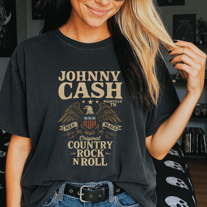May include: Black t-shirt featuring the text "JOHNNY CASH" in a vintage style, with an eagle graphic and the words "Original Country Rock N Roll". The shirt design includes the words "Man" and "Black".