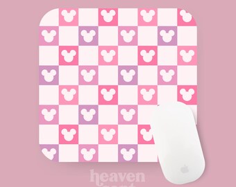 Peut inclure: Un tapis de souris à carreaux rose et violet avec un motif d'oreilles de souris blanches. Le tapis de souris porte le texte "heaven sent babes" en bas.