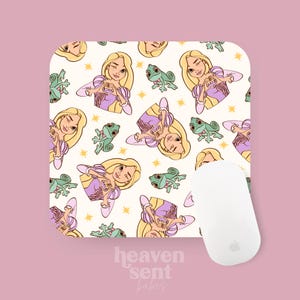 Peut inclure: Un tapis de souris blanc avec un motif répété d'une princesse de dessin animé aux longs cheveux blonds, une robe violette et un lézard vert. La princesse fait un cœur avec ses mains. Le texte "heaven sent babes" est imprimé sous le tapis de souris.