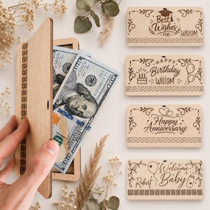 May include: A wooden money holder with $100 bills inside, next to engraved wooden gift tags. The tags read "Best Wishes for William", "Happy Birthday William", "Happy Anniversary", and "Welcome Baby Robert".