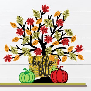Puede incluir: Una ilustración de otoño con un árbol de hojas coloridas, un cartel que dice "hello fall" y dos calabazas, una verde y una roja.