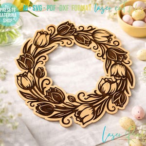 May include: A wooden wreath featuring a tulip design, perfect for laser cutting. The wreath is light brown with darker brown etched details. The text "AI - SVG - PDF - DXF FORMAT laser cut files" is visible. The wreath is surrounded by Easter eggs and flowers.