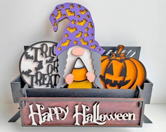May include: A wooden Halloween decoration featuring a gnome with a purple hat adorned with bats and stars, holding candy corn. The display includes a pumpkin, a sign that says "Trick or Treat", and a sign that says "Happy Halloween".