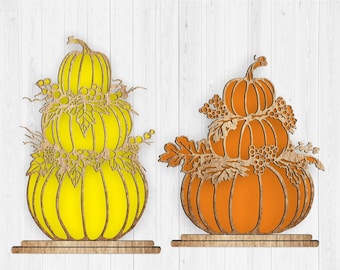 May include: Two wooden pumpkin stacks, one yellow and one orange, with fall foliage accents. The pumpkins are layered on top of each other and have a rustic, farmhouse style.