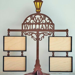 May include: A wooden picture frame stand with a street lamp design. The stand has four picture frames and a sign that says "Williams".