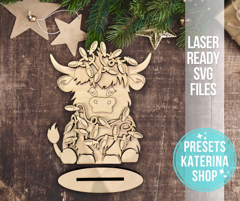 May include: A wooden cutout of a Highland cow with a festive garland of lights around its neck. The cutout is designed for laser cutting and is part of a set of SVG files.