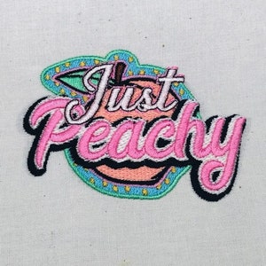 May include: Embroidered patch with a peach design and the text "Just Peachy" in pink and black lettering. The peach is surrounded by a blue and green border with yellow stars.