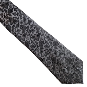 May include: A gray and black patterned tie with a floral design.