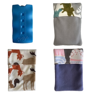 May include: Four different fabric pouches with various designs. The pouches are all made of soft, plush fabric and feature different patterns, including dinosaurs, deer, and cupcakes. The pouches are all approximately 10 inches long and 6 inches wide.