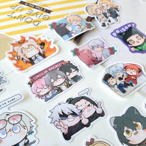 May include: A collection of anime-style stickers featuring various characters in different poses. Some stickers depict couples, while others show individual characters with unique expressions. The stickers are colorful and have a glossy finish.