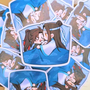 May include: A selection of stickers depicting an anime-style illustration of two characters cuddling in bed. The stickers are predominantly blue and white, with brown-haired characters. The image has a cartoonish aesthetic.