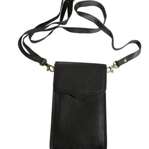 May include: A black leather phone case with a long adjustable strap. The case has a flap that closes with a snap.