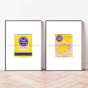 May include: Two framed prints featuring vintage Blue Star potato chip boxes. One box is yellow with a blue star logo and the words "Potato Chips." The other box is yellow with "RIPPLED Potato Chips."
