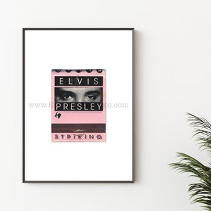 May include: A vintage matchbook with a pink background and black text that reads "ELVIS PRESLEY" with a black and white image of Elvis Presley's eyes. The bottom of the matchbook reads "STRIKING".